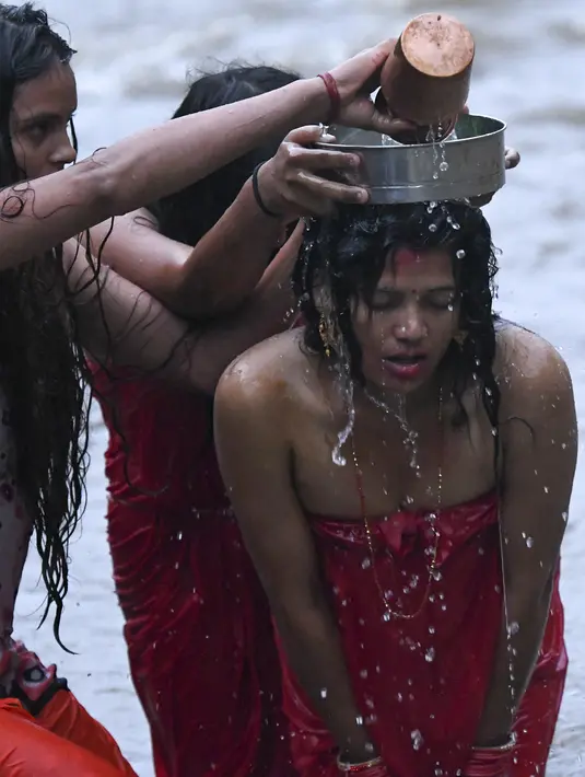Wanita Hindu Nepal mandi suci di sungai Bagmati selama festival Rishi Panchami di Kathmandu (3/9/2019). Di festival ini para wanita berpuasa di siang hari dan berdoa untuk umur panjang untuk suami mereka. (AFP Photo/Prakash Mathema)