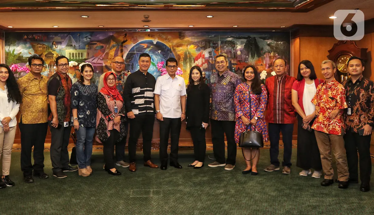 Menteri Pariwisata dan Ekonomi Kreatif Wishnutama (tengah) dan Wakil Menteri Angela Tanoesoedibjo (ketujuh kanan) foto bersama jajaran Emtek dan SCM Group saat menerima kunjungan di Kantor Kemenpar, Jakarta, Jumat (8/11/2019). Pertemuan membahas kerja sama sektor media. (Liputan6.com/JohanTallo)
