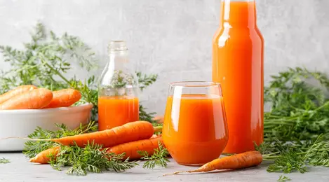 Segelas jus wortel segar dengan warna oranye cerah, kaya vitamin dan manfaat untuk kesehatan tubuh