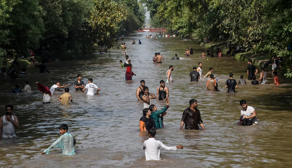 Penduduk mendinginkan diri dalam aliran kanal sungai saat suhu mencapai 40 derajat celsius di Lahore, Pakistan pada Rabu (27/5/2020). Banyak kota di Pakistan menghadapi kondisi gelombang panas dengan suhu mencapai 50 derajat celsius di beberapa tempat.  (Photo by Arif ALI / AFP)