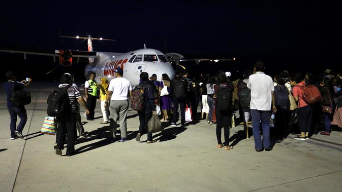 Ratusan calon penumpang berebut masuk ke pesawat Wings Air tujuan Makasar di Bandara Mutiara Palu, Selasa (2/10). Mereka sudah memesan atau memiliki tiket penerbangan sebelum gempa terjadi. (Liputan6.com/Fery Pradolo)