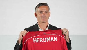 Sebagai informasi, John Herdman datang ke Indonesia dengan membawa sejumlah pengalaman sukses, terutama saat bertugas di Kanada. Dia mengantar timnas putri Kanada meraih dua medali perunggu berturut-turut dalam Olimpiade 2012 dan 2016. Tampak dalam foto, pelatih kepala tim nasional sepak bola Indonesia yang baru, John Herdman memegang jersey tim yang bertuliskan namanya saat konferensi pers di Jakarta, Selasa 13 Januari 2026. (AP Photo/Achmad Ibrahim)