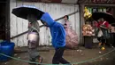 Orang-orang berjalan saat hujan di Kohima, Nagaland, India, Senin (16/5/2022). Delapan orang tewas akibat banjir dan tanah longsor yang dipicu oleh hujan lebat di wilayah timur laut India. (AP Photo/Yirmiyan Arthur)