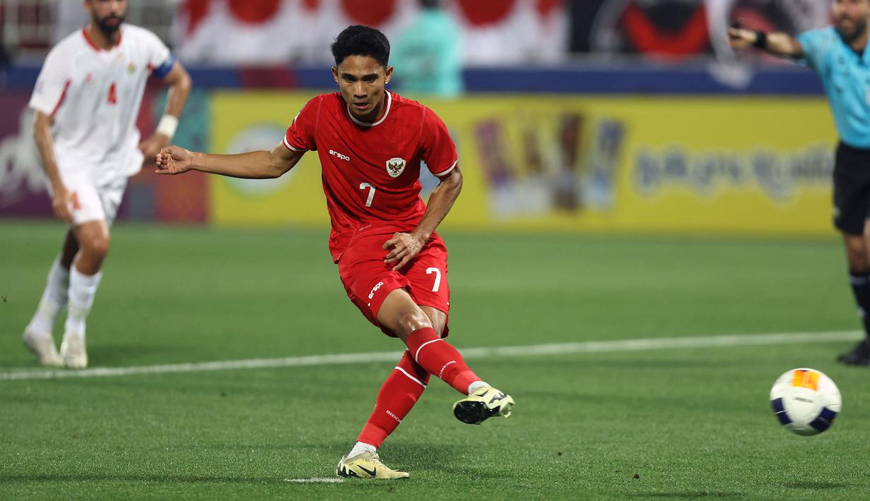 Pemain Timnas Indonesia U-23, Marselino Ferdinan melakukan eksekusi penalti yang berbuah gol pertama ke gawang Yordania U-23 pada laga ketiga Grup A Piala Asia U-23 2024 di Abdullah bin Khalifa Stadium, Doha, Qatar, Minggu (21/4/2024). (AFP/Karim Jaafar)