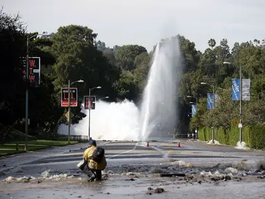 Sebuah pipa utama saluran air bawah tanah rusak di sekitar Sunset Boulevard di bagian Westwood, Los Angeles, (29/7/2014). (REUTERS/Danny Moloshok)