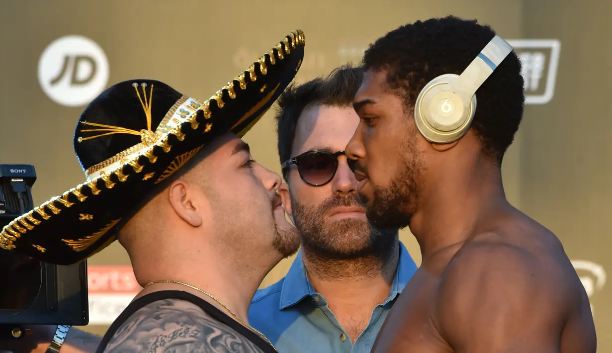 Petinju kelas berat Anthony Joshua (kanan) dan Andy Ruiz Jr (kiri) berpose saat timbang badan resmi di Riyadh, Arab Saudi, Jumat (6/12/2019). Andy Ruiz Jr tercatat memiliki bobot 128,6 Kg, sementara Anthony Joshua 107,5 Kg. (Fayez Nureldine/AFP)