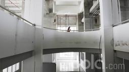 Seorang pekerja melintas di dalam pembangunan wisma Atlet di Kemayoran. Wisma Atlet Kemayoran ini menempati area seluas 10 hektar. (Bola.com/M Iqbal Ichsan)
