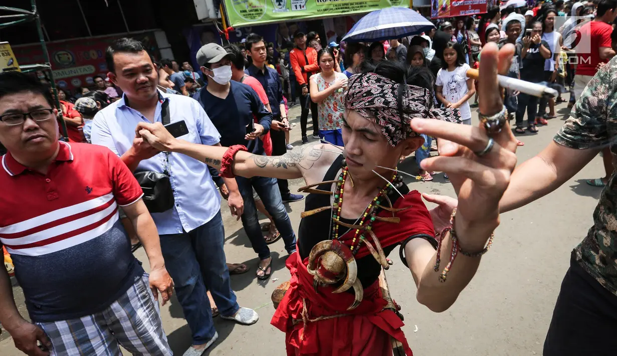 Tatung pria melakukan atraksi dalam Festival Cap Go Meh 2570 di Seasons City, Jakarta,  Minggu (24/3). Sekitar 100 tatung pria dan wanita hadir menampilkan atraksi ekstrem menggunakan benda tajam. (Liputan6.com/Fery Pradolo)