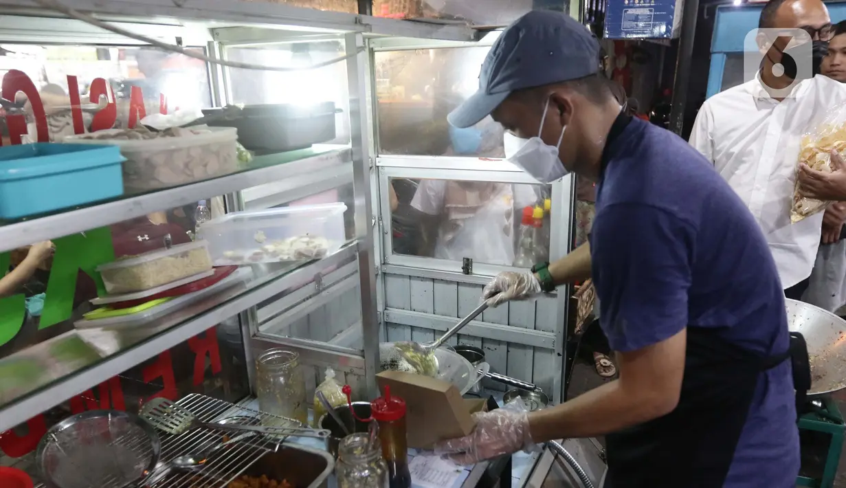 Mantan pegawai fungsional Biro Hukum KPK, Juliandi Tigor Simanjuntak memasak nasi goreng pesanan pelanggan di Jalan Raya Hankam, Bekasi, Rabu (13/10/2021). Tigor berjualan nasi goreng setelah dipecat KPK bersama 57 rekannya yang tidak lolos tes wawasan kebangsaan. (Liputan6.com/Helmi Fithriansyah)