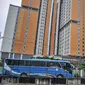 Bus yang mengangkut TKI dari luar negeri mengantre masuk untuk menjalani karantina di RSDC Wisma Atlet Kemayoran, Jakarta, Kamis (16/12/2021). Menkes Budi Gunadi Sadikin mengumumkan temuan kasus varian Omicron dari pekerja kebersihan di RSDC Wisma Atlet Kemayoran. (merdeka.com/Iqbal S. Nugroho)