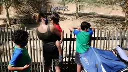 Para pengunjung melihat zebra di Kebun Binatang Los Angeles, Amerika Serikat (AS), pada 26 Agustus 2020. Kebun binatang tersebut dibuka kembali untuk umum dengan menerapkan langkah-langkah pencegahan kesehatan setelah ditutup selama 166 hari akibat pandemi COVID-19 yang masih merebak. (Xinhua)