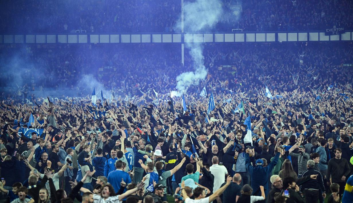 Suporter Everton menyerbu lapangan untuk merayakan akhir pertandingan Liga Inggris antara Everton dan Crystal Palace di Goodison Park di Liverpool, Inggris, 19 Mei 2022. Everton berhasil menang lewat come back dramatis 3-2 dan keluar dari zona degradasi Liga Inggris. (AFP/Oli Scarff)