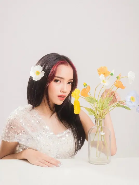 Tampil anggun bak gadis telenovela, Fuji bermain-main dengan bunga. Bahkan rambutnya pun dibuat panjang semakin menegaskan sisi feminin pemilik nama lengkap Fujianti Utami Putri tersebut.(Liputan6.com/IG/@fuji_an)
