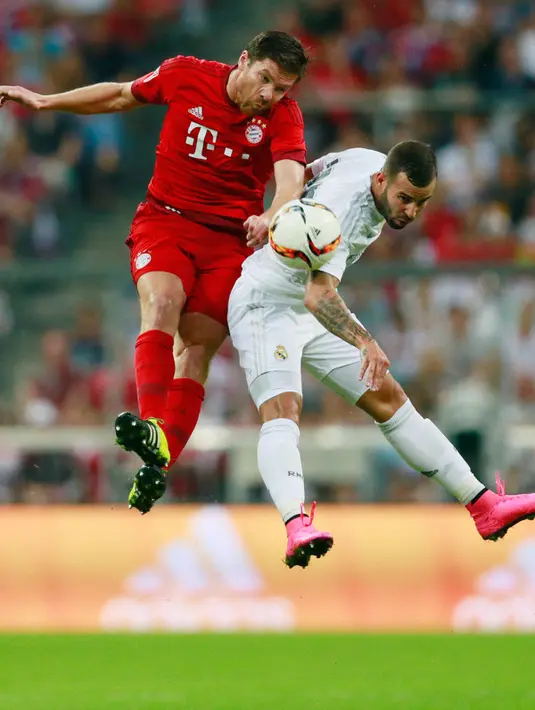 Gelandang Bayern Muenchen Xabi Alonso berebut bola udara dengan Striker Real Madrid Jese Rodriguez pada laga final  Audi Cup 2015, Allianz Arena , Munich , Jerman, Kamis (6/8/2015). Bayern Muenchen menang dengan skor 1-0. (Reuters/Jason Cairnduff)
