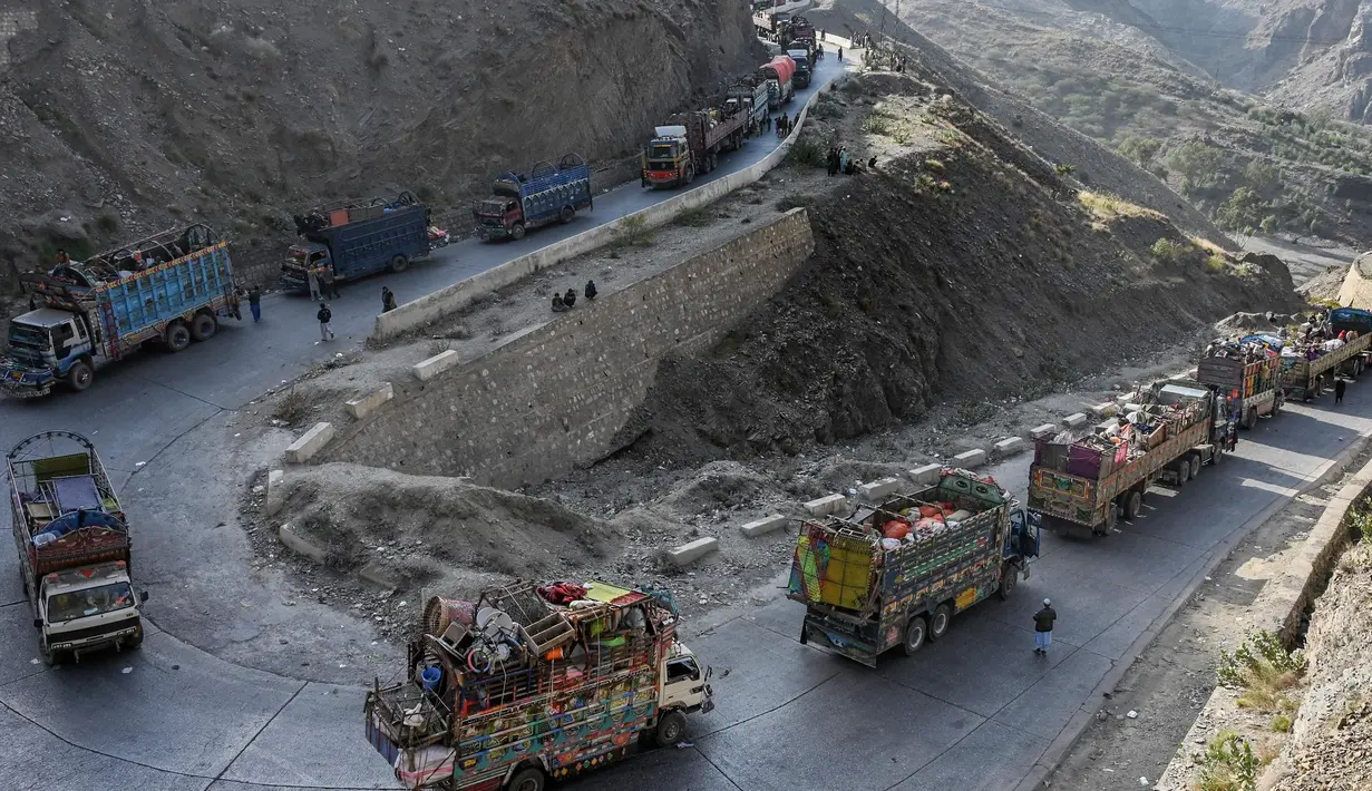 Truk-truk yang mengangkut para pengungsi Afghanistan beserta barang-barang mereka terlihat di sepanjang jalan menuju perbatasan Torkham Pakistan-Afghanistan pada tanggal 3 November 2023. (Abdul MAJEED/AFP)