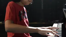 Pianis belia asal Indonesia, Joey Alexander saat latihan bermain piano di Prancis, 10 Agustus 2015. Pianis jazz berusia 12 tahun itu menjadi musisi pertama asal Tanah Air yang masuk nominasi ajang Grammy Awards 2016.  (AFP PHOTO/PASCAL Pavani)