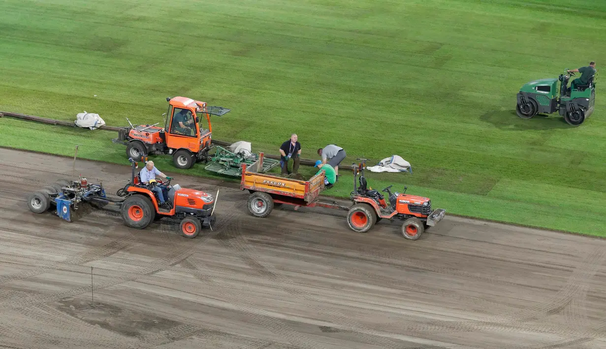 Sejumlah kendaraan traktor menghaluskan permukaan tanah sebelum pemasangan rumput baru di Stade Pierre Mauroy, Prancis (23/6). Jelang laga 16 besar dan final Piala Euro 2016 pihak penyelenggara memperbaiki rumput lapangan bola. (REUTERS/Carl Recine)
