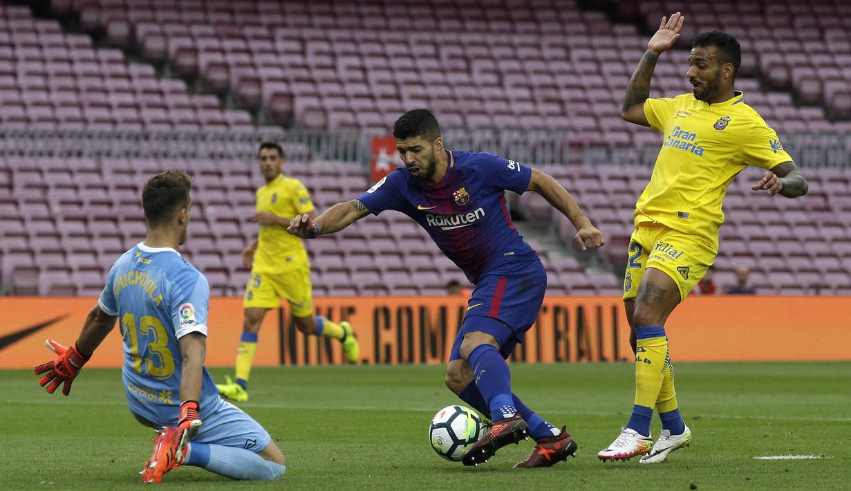 Striker Barcelona, Luis Suarez, berusaha melewati kiper Las Palmas, Leandro Chichizola, pada laga La Liga Spanyol di Stadion Camp Nou, Katalonia, Minggu (1/10/2017). Barcelona menang 3-0 atas Las Palmas. (AP/Manu Fernandez)