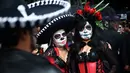 Orang-orang berpakaian seperti "Catrina" ambil bagian dalam parade Hari Orang Mati di Reforma Avenue, Mexico City, 21 Oktober 2018. Banyak orang yang menggenakan kostum tengkorak dan hiasan serba tongkorak yang memenuhi jalanan. (RODRIGO ARANGUA/AFP)