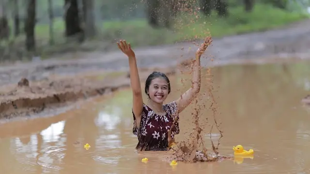 Wanita yang sedang berfoto di lumpur