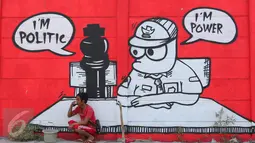 Warga bersantai di depan mural bernuansa politik di Penjaringan, Jakarta, Minggu (7/8). Jelang Pilkada 2017, sejumlah lokasi di Jakarta dihiasi mural politik. (Liputan6.com/Angga Yuniar) 