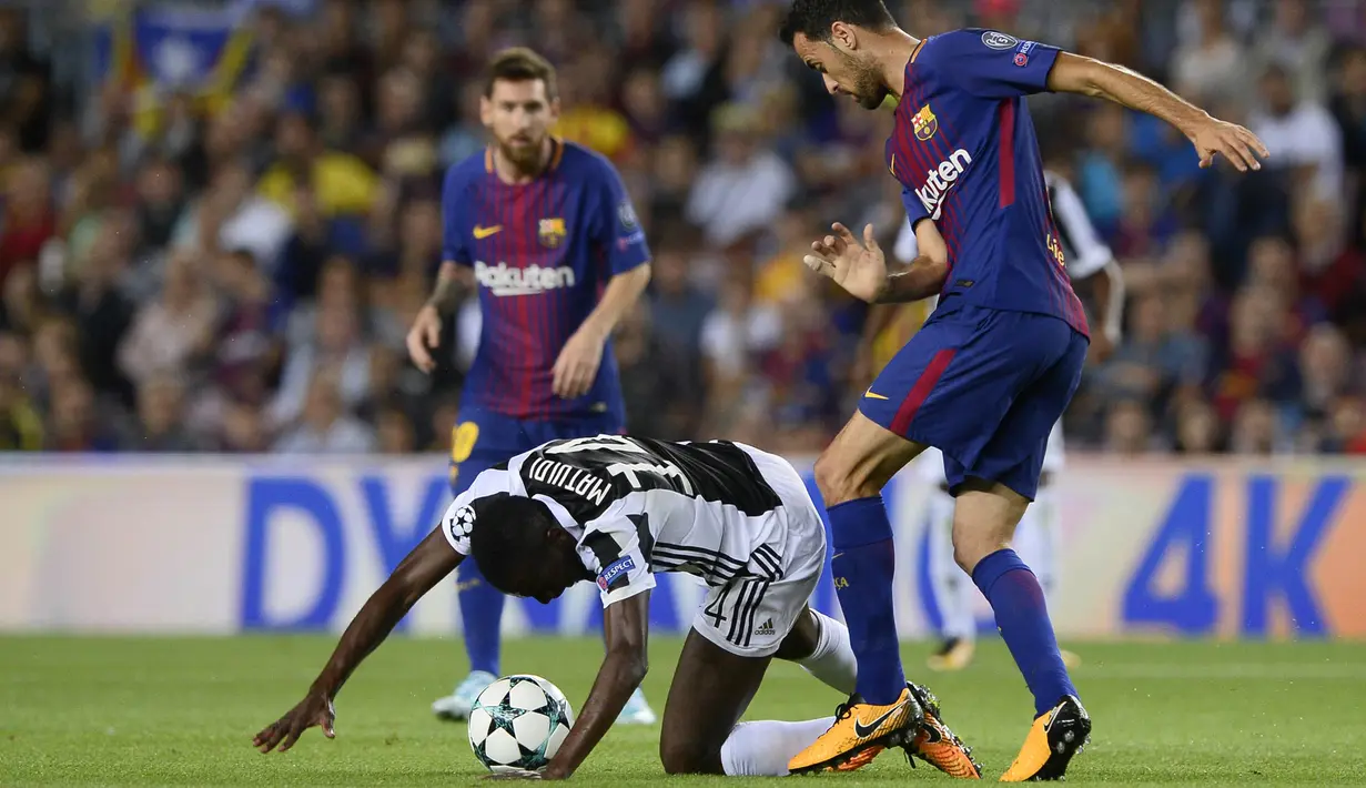 Gelandang Juventus, Blaise Matuidi, dijatuhkan gelandang Barcelona, Sergio Busquets, pada laga Liga Champions di Stadion Camp Nou, Katalonia, Selasa (12/9/2012). Barcelona menang 3-0 atas Juventus. (AFP/Josep Lago)