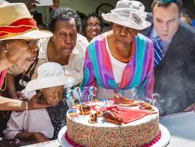 Susannah Mushatt Jones (duduk) yang dikenal sebagai "Miss Susie" meniup lilin saat perayaan ulang tahun ke-116 bersama keluarga di Brooklyn borough, New York, 7 Juni 2015. Miss Susie dinobatkan sebagai wanita tertua di dunia. (REUTERS/Lucas Jackson)