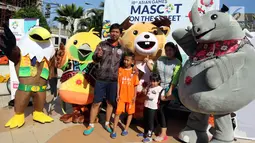 Warga berfoto dengan tiga maskot Asian Games 2018 saat hari bebas kendaraan bermotor di kawasan Bundaran HI, Jakarta, Minggu (1/4). Ketiga maskot tersebut menyapa masyarakat dalam rangka sosialisasi Asian Games 2018. (Liputan6.com/Arya Manggala)