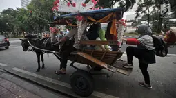 Warga menaiki delman di kawasan Monas, Jakarta, Selasa (3/7). Larangan beroperasi bagi delman di Jakarta Pusat saat Asian Games diberlakukan untuk mengantisipasi penularan virus oleh kuda. (Merdeka.com/Iqbal Nugroho)