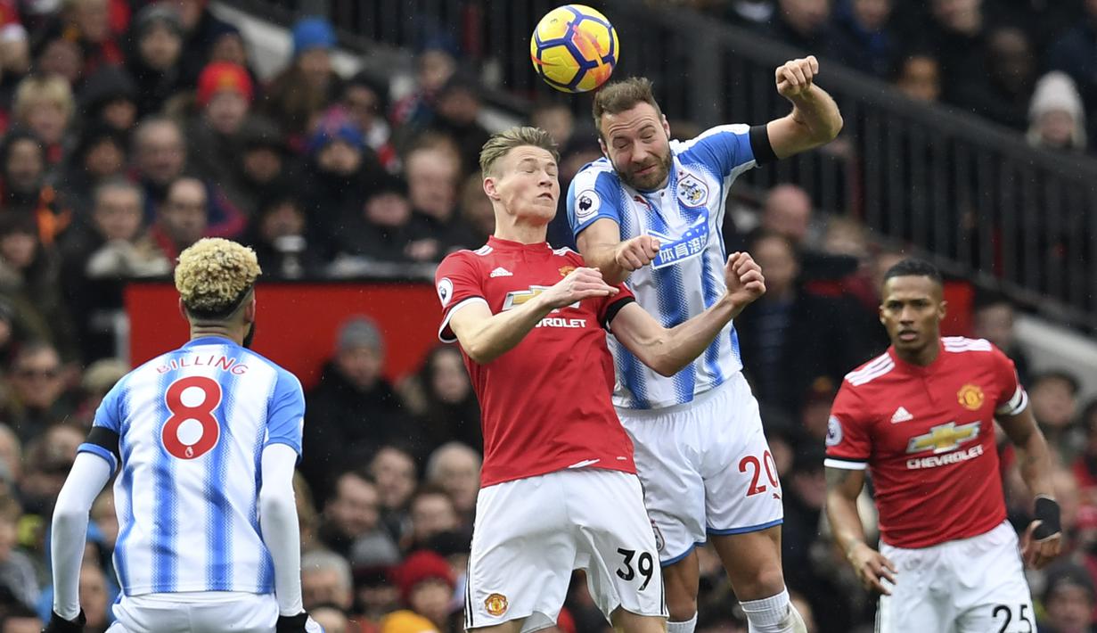 Duel pemain Manchester United, Scott McTominay (2kiri) dan pemain Huddersfield Town, Laurent Depoitre pada laga Premier League di Old Trafford, Manchester, (3/2/2018). MU menang 2-0. (AFP/Paul Ellis)