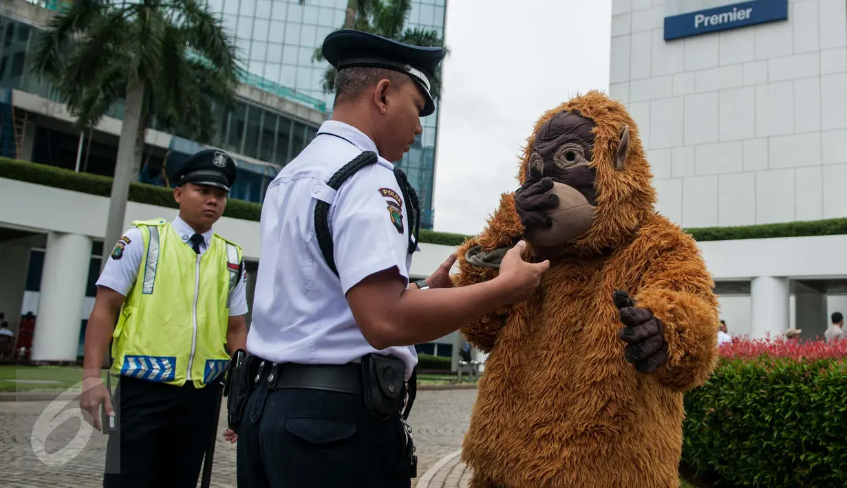 Petugas menghalau aktivis Orangutan di kawasan kantor HSBC, Jakarta, Kamis (9/2). Aksi tersebut ditujukan kepada HSBC agar menghentikan peranannya mendanai perusahaan minyak sawit yang merusak hutan dan gambut. (Liputan6.com/Gempur M Surya)