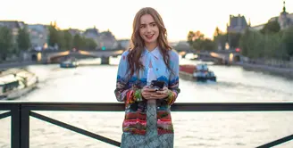 Ini adalah penampilan Lily Collins di Emily in Paris season 1. Ia mengenakan Alice + Olive Eiffel Tower blouse, Ronny Kobo skirt, dan cropped top berwarna putih. Foto: Netflix.