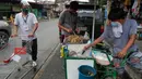 Seorang pria yang mengenakan masker membeli makanan dari warung kaki lima di kota Quezon, Filipina, Selasa (22/9/2020). Presiden Filipina Rodrigo Duterte mengatakan telah memperpanjang status masa darurat virus corona (Covid-19) di negaranya hingga satu tahun ke depan. (AP Photo/Aaron Favila)