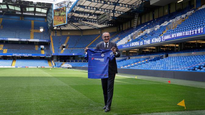 Pelatih baru Chelsea, Maurizio Sarri berpose dengan jersey tim usai konferensi pers di Stamford Bridge di London (18/7). Pria Italia 59 ini resmi menjadi manajer Chelsea selama tiga musim. (AP Photo/Kirsty Wigglesworth)