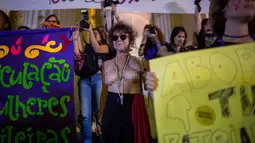 Seorang wanita bertelanjang dada saat mengikuti protes pelarangan aborsi di Rio de Janeiro, Brasil (13/11). Para demonstran ini meminta aborsi dilegalkan dalam kasus pemerkosaan dan kehamilan yang mengancam kehidupan. (AFP Photo/Mauro Pimentel)