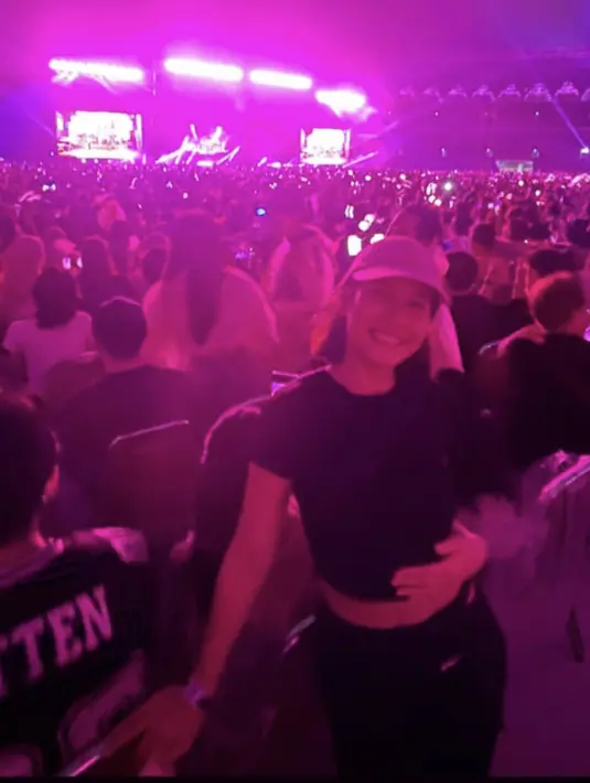 Pevita Pearce menikmati konser dengan mengenakan atas crop top hitam yang serasi dengan celananya. (@pevpearce)