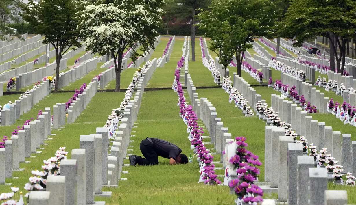 Warga Korea Selatan Park Ung-gi membungkuk di depan nisan pamannya Park Tae-son yang gugur saat Perang Korea pada peringatan Hari Pahlawan di Pemakaman Nasional Seoul, Seoul, Korea Selatan, Senin (6/6/2022). (AP Photo /Ahn Young-joon)