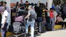Penumpang yang terdampar menunggu penerbangan mereka di bandara JKIA, Nairobi, Rabu (6/3). Aksi mogok dipicu dengan rencana penyerahan manajemen bandara terbesar di Kenya kepada maskapai nasional yang merugi. (AP Photo/Khalil Senosi)