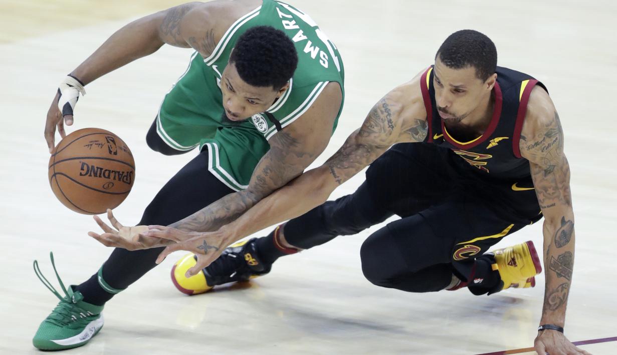 Pemain Boston Celtics, Marcus Smart (kiri) mencoba melewati pemain Cleveland, George Hill pada gim keempat final Wilayah Timur NBA basketball di Quicken Loans Arena (21/5/2018). Cavaliers menang 111-102. (AP/Tony Dejak)