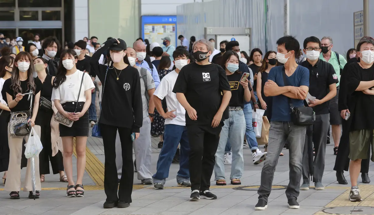 <p>Warga yang mengenakan masker untuk melindungi diri dari penyebaran COVID-19 berdiri di persimpangan di Tokyo, Jepang, Selasa (27/7/2021). Tokyo melaporkan jumlah kasus harian COVID-19 tertinggi beberapa hari setelah Olimpiade dimulai. (AP Photo/Koji Sasahara)</p>