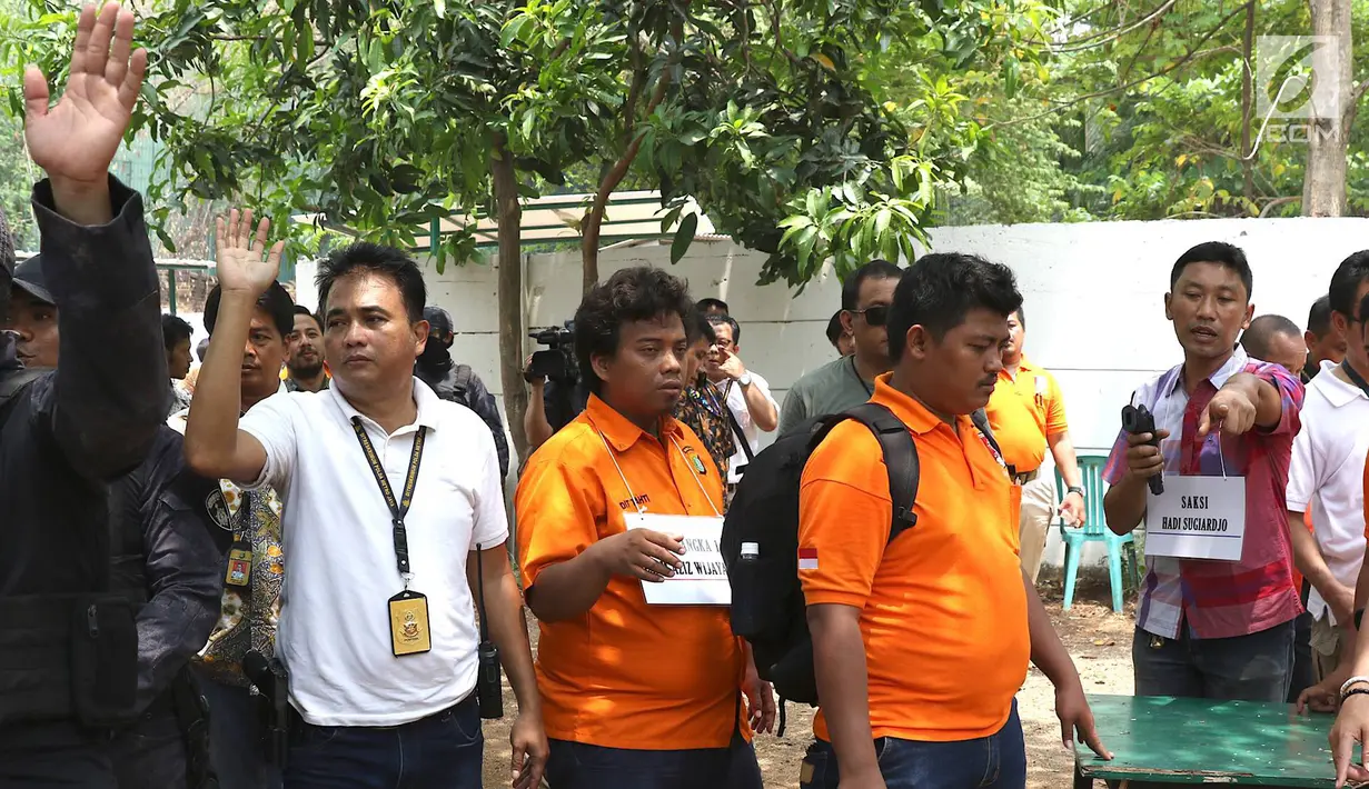 Tersangka IAW menjalani proses rekonstruksi Lapangan Tembak Senayan, Jakarta, Jumat (19/10). IAW menjalani 25 adegan rekonstruksi terkait dugaan enam peluru yang tertembak ke enam ruangan di Gedung DPR RI. (Liputan6.com/Immanuel Antonius)