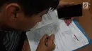 Warga mengisi dokumen saat mengurus surat pindah tempat memilih atau Formulir A5 Pemilu 2019 di Kantor KPUD Jakarta Selatan, Jakarta, Rabu (10/4). Hari ini merupakan batas akhir pembuatan Formulir A5. (Liputan6.com/Herman Zakharia)