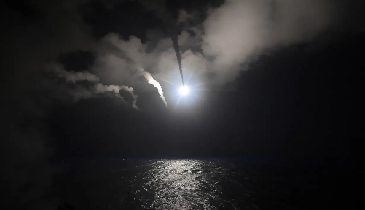 Rudal Tomahawk ditembakkan kapal perang AS yang ada di Laut Mediterania,menyasar pangkalan udara Suriah, Jumat (7/4). Perintah serangan terbuka ini yang pertama dilakukan Donald Trump sepanjang kepemimpinannya sebagai Presiden AS. (U.S. Navy via AP)