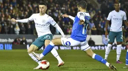 Pemain Manchester City Phil Foden (kiri) berebut bola dengan pemain Peterborough United Jorge Grant pada pertandingan sepak bola putaran kelima Piala FA di Stadion Weston Homes, Peterborough, Inggris, 1 Maret 2022. Manchester City menang 2-0. (AP Photo/Rui Vieira)