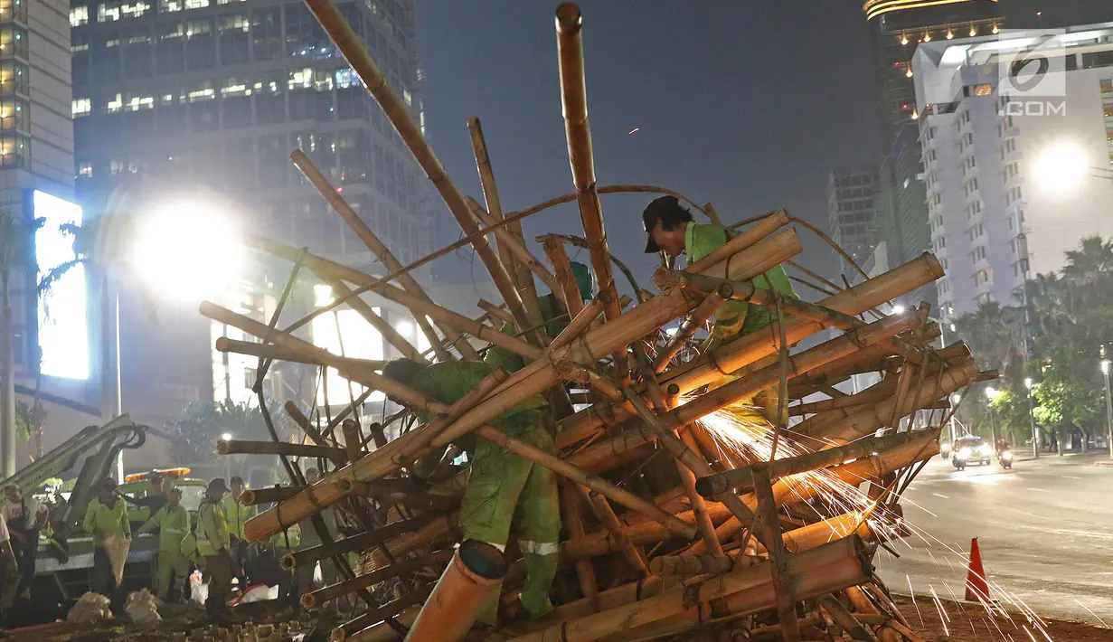 Aktivitas pembongkaran instalasi bambu Getah Getih di Bundaran Hotel Indonesia (HI), Jakarta, Kamis (18/7/2019) dini hari. Karya seni tersebut rencananya akan diganti dengan taman dan setelah dibongkar, bambu itu akan dibawa ke tempat pembuangan sampah. (Liputan6.com/Herman Zakharia)