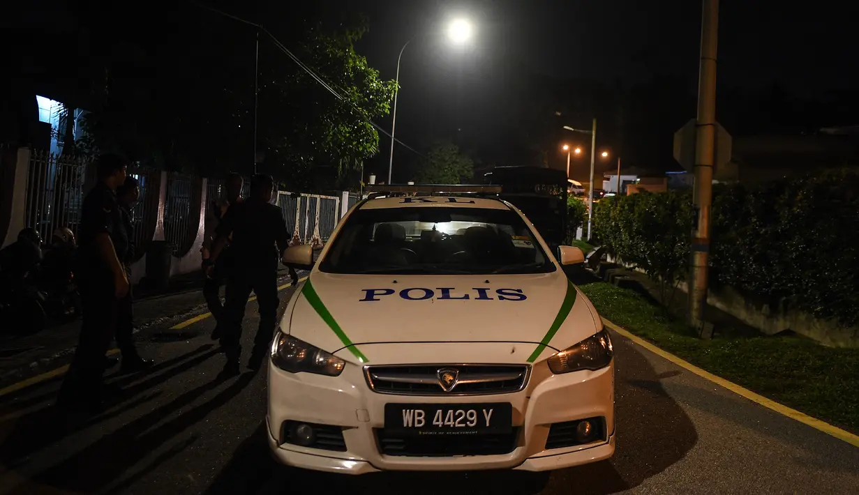 Mobil polisi terparkir di jalan menuju rumah mantan Perdana Menteri Malaysia, Najib Razak di Kuala Lumpur, Rabu (16/5). Polisi melakukan penggeledahan terkait dugaan pencucian uang di kediaman Najib usai Salat Tarawih. (AFP/Mohd RASFAN)