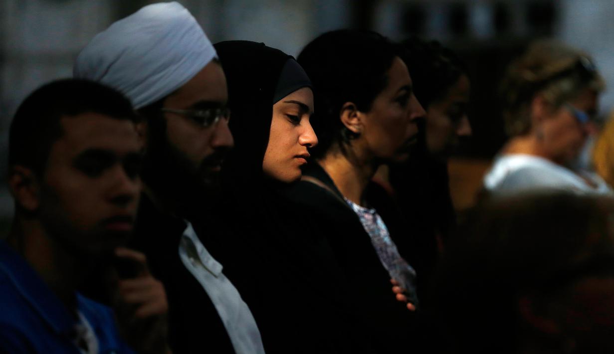 Seorang wanita muslim menghadiri misa di Katedral Rouen, Prancis, Minggu (31/7). Muslim di penjuru Prancis menghadiri misa sebagai solidaritas atas pembunuhan pastor Jacques Hamel oleh militan Islam. (Charly Triballeau/AFP)
