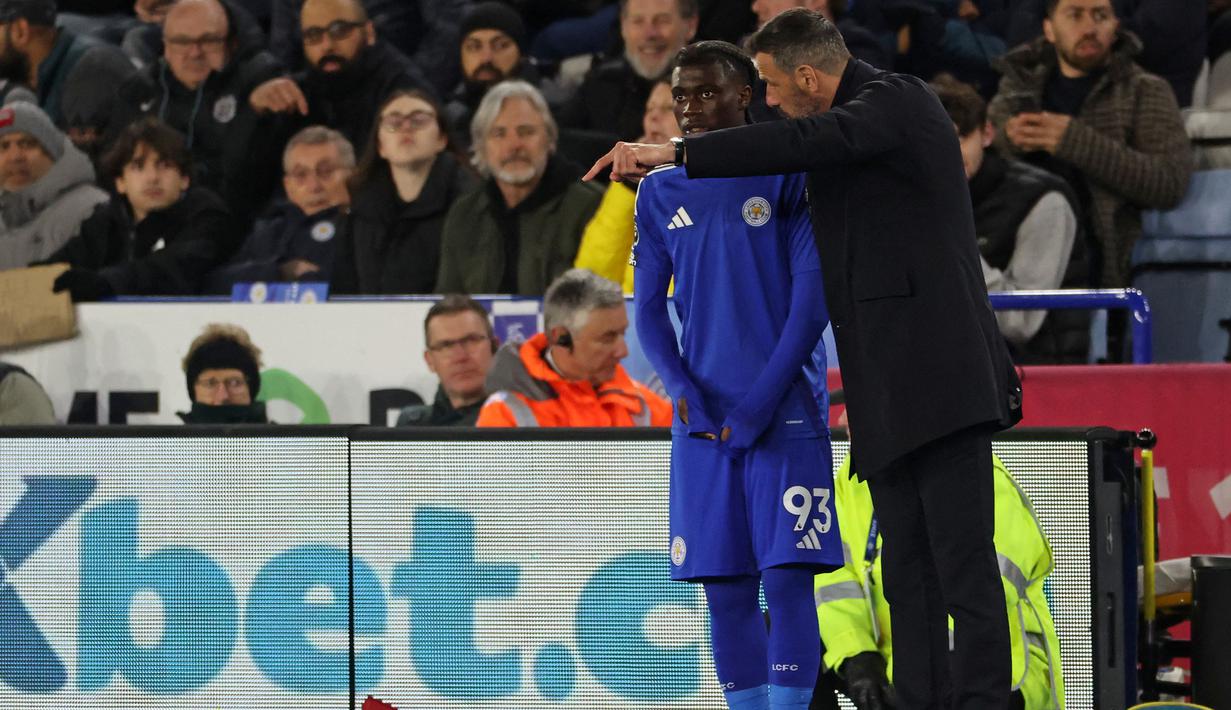 Pemain Leicester, Jeremy Monga mendengarkan instruksi pelatih Ruud Van Nistelrooy sebelum memasuki lapangan pertandingan dalam laga lanjutan Liga Inggris 2024/2025 melawan Newcastle di King Power Stadium, Leicester, Inggris, Senin (07/04/2025) waktu setempat. (AFP/Darren Staples)
