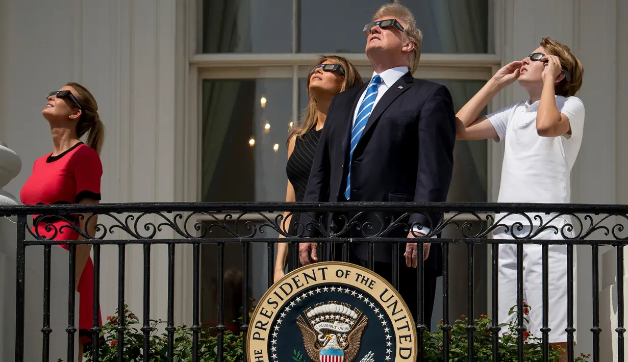 (Dari kiri) Ivanka Trump bersama sang ayah yang juga Presiden AS, Donald Trump dan Ibu Negara, Melania Trump serta putra mereka, Barron Trump menyaksikan fenomena langka gerhana matahari total dari balkon Gedung Putih, Senin (21/8). (AP/Andrew Harnik)
