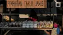 Seorang anak berdiri di depan tumpukan takjil yang akan dibagikan di Jalan Cempaka Putih Raya, Jakarta, Senin (11/5/2020). Setiap hari selama Ramadan, masyarakat sekitar membagikan 350 takjil kepada warga kurang mampu dan terdampak virus corona COVID-19. (Liputan6.com/Johan Tallo)